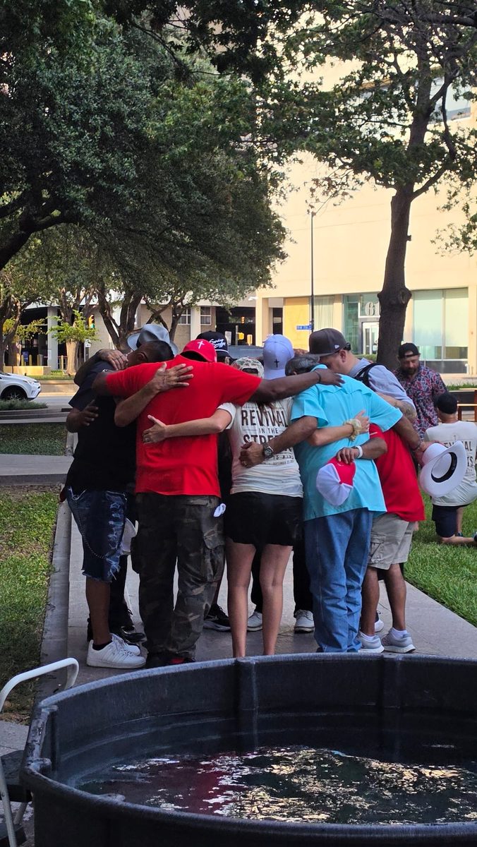 A group of people embracing beside the baptism tub